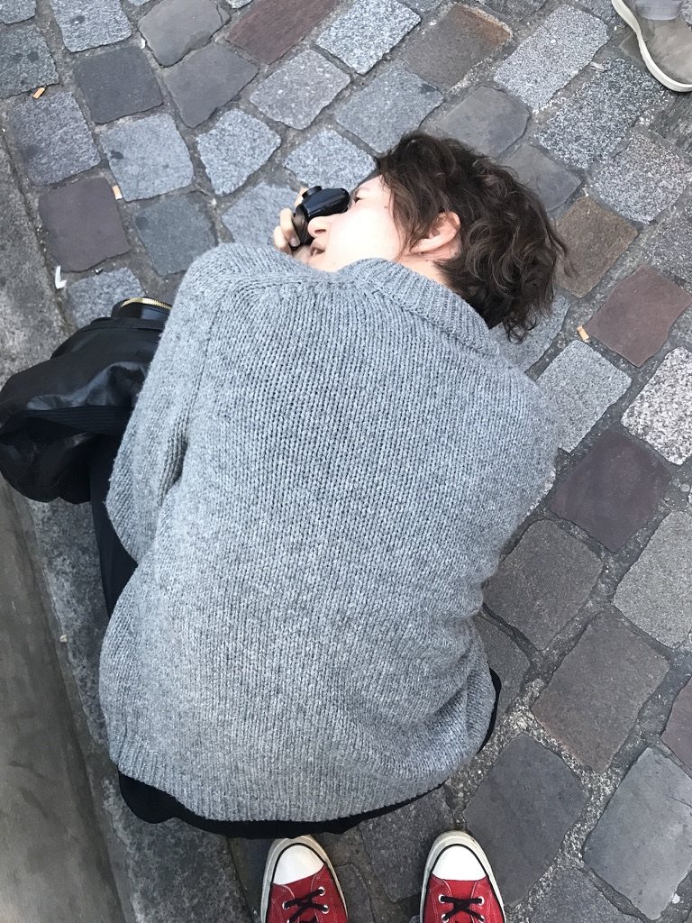 Maria lying on the cobblestones to take a photograph