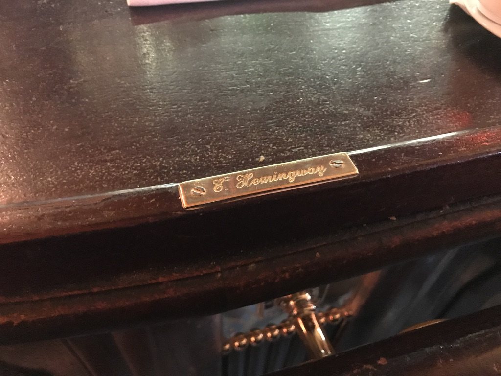 A small brass plate engraved E. Hemingway on a dark wooden bar